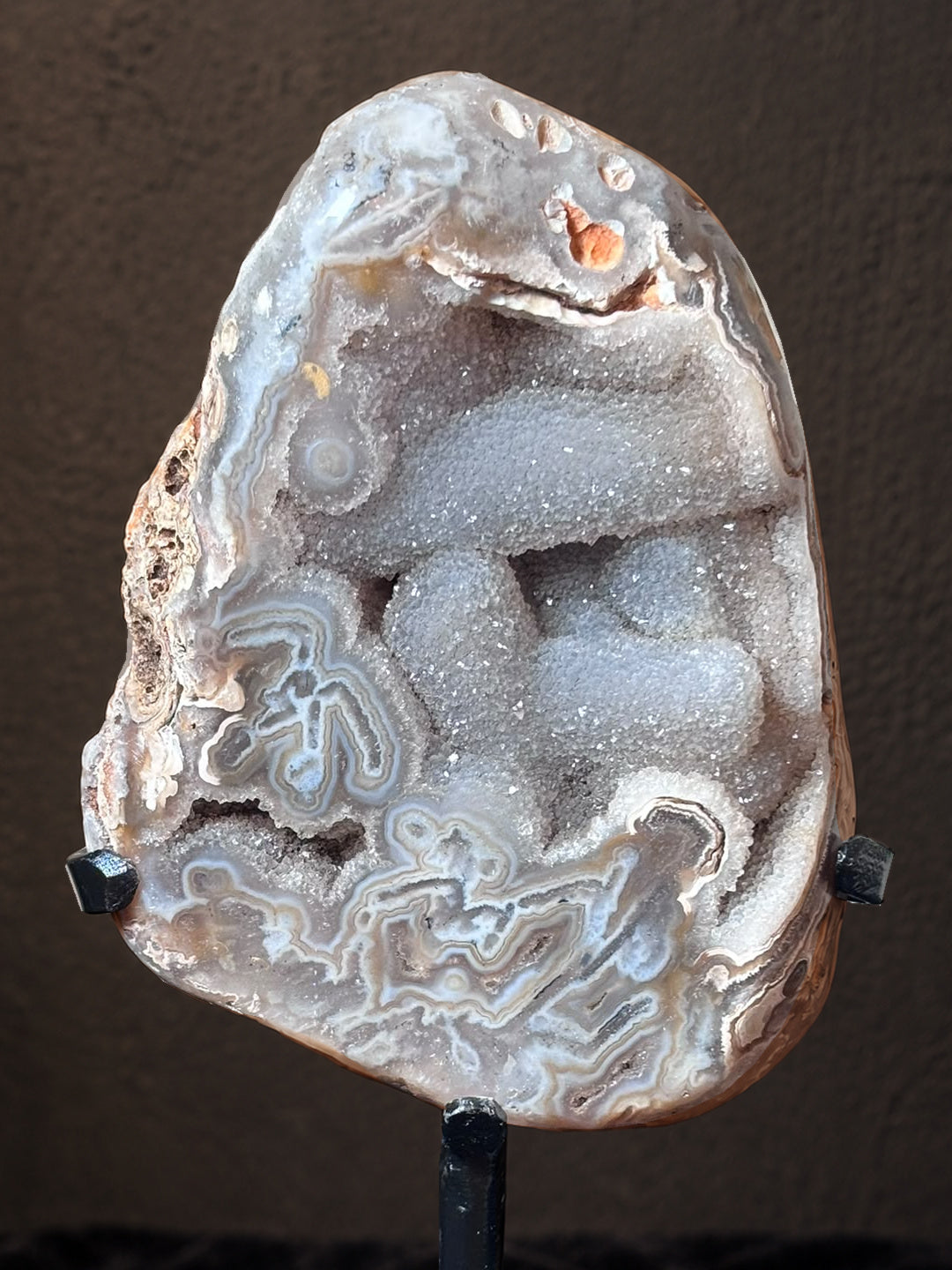 Close view of Brazilian agate showing intricate banding and sparkling druzy quartz cavities