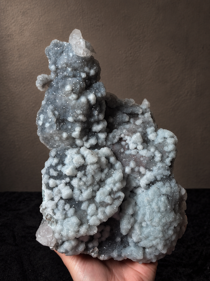 Reverse view of a large Xianghualing mineral specimen showing branching grey chalcedony formations and pale crystalline growth.